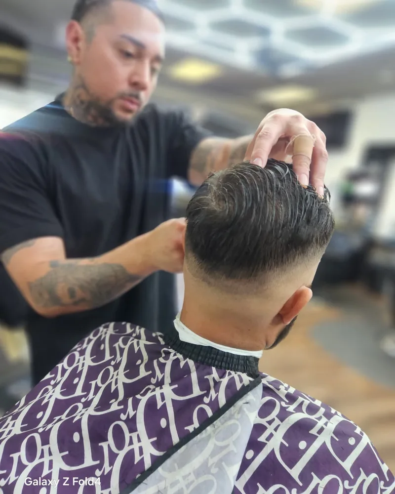 Barbero cortando el pelo con estilo a un cliente
